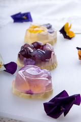 Unique japanese dessert Havaro of jelly and bavarian cream with edible violet flowers. Gelatin healthy eating dessert.