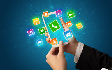 Female hand using smartphone with 3D shiny starlike application icons around
