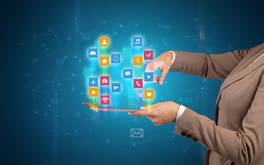 Female elegant hand holding tablet with colourful application icons