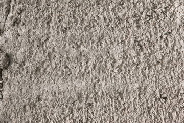 Warm textured concrete wall as an abstract background. Uneven concrete surface
