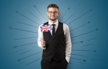 Smiling young man standing with flag and multidirectional arrows around
