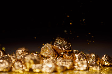 golden stones on sparkling surface and black background