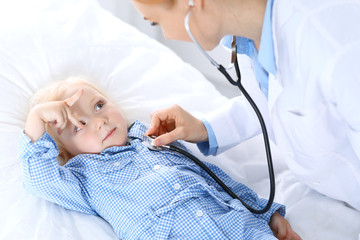 Doctor and a little blonde girl. Usual health exam. Medicine and healthcare concept