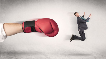 Businessman gets fired from his job by a huge hand in boxing gloves