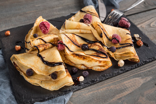 Sweet crepes wrapped with fresh berries and chocolate
