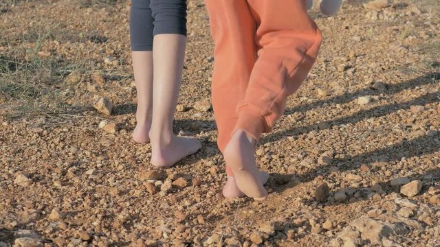 body part of children's feet. little refugees standing on a dirt road barefoot with no shoes on close up. concept poverty and homeless