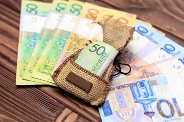 wooden background. on it laid out Belarusian money. In the center in the bag 50 rubles