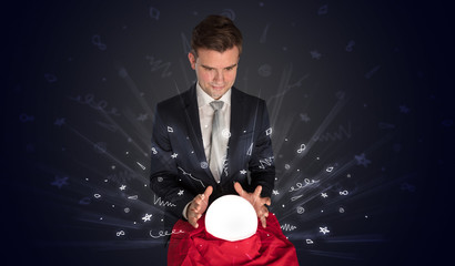 Gorgeous businessman looking to inspiration in a magic ball in his lap and doodle concept
