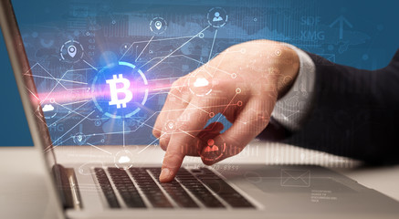 Hand checking on laptop global bitcoin exchange rate concept
