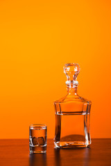 glass and decanter with alcohol on red background