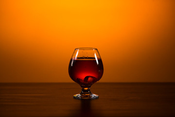 glass with alcohol on a yellow background