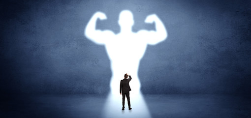 Businessman standing and dreaming about a strong superhero