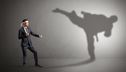 Young karate man confronting with his own shadow
