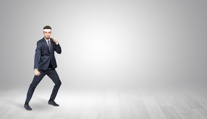 Young businessman in suit fighting in an empty space
