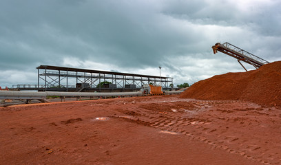 Industrial machinery for transhipment of bauxite ore from mining trains to bulk carrier ships. Kamsar, Guinea.
