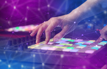 Hand remixing music on midi controller with colorful connectivity concept
