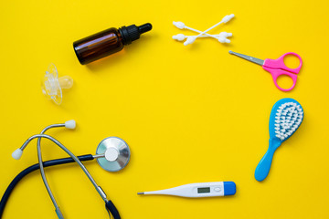 Medical items for baby on yellow background. Newborn health. Copy space and top view.