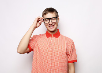 Portrait of a smart young man wearing eyeglasses standing against white background