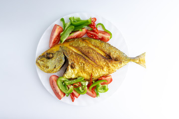 Fried fish on white background with selective focus and crop fragment