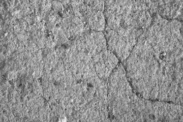 Grey textured concrete wall as an abstract background with cracks for poster, calendar, post, screensaver, wallpaper, postcard, card, banner, cover, website. A place for your design or text
