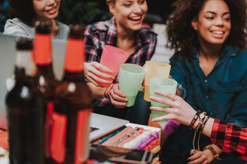 Cheerful female company drinking beverage in room