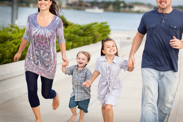 Happy Young Family Running Together Outside