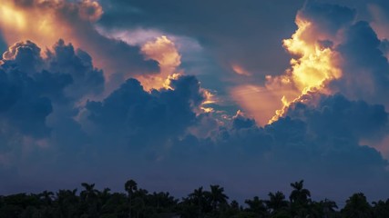 Epic storm tropical clouds over palm trees silhouettes landscape at sunset. 4K UHD Timelapse.