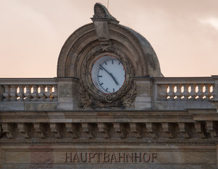 Clock on a building with marble walls and lettering "Hauptbahnhof" - Central Station