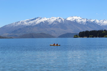 Kayaking on the lake with snowy mountains behind
