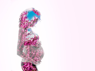 Double exposure. Silhouette of pregnant woman combined with pink flowers, symbolizing the spring or mother nature