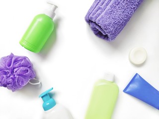 Obraz na płótnie Canvas Flat lay photo liquid soap, shampoo, shower gel, cream, purple towel, sponge on a white background. Mockup with copy space
