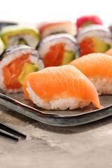 close up of sashimi sushi set with chopsticks and soy - sushi roll with salmon and sushi roll with smoked eel