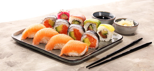 close up of sashimi sushi set with chopsticks and soy - sushi roll with salmon and sushi roll with...