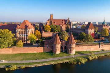 Medieval Malbork (Marienburg) Castle in Poland, main fortress of the Teutonic Knights at the Nogat river. Aerial view in fall in sunset light.