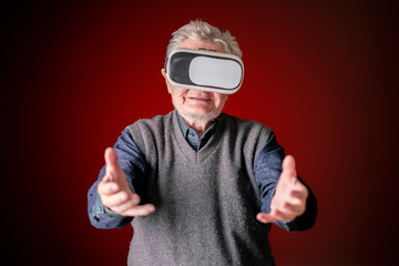 Naklejka premium amazed old senior bearded man play vr video games b