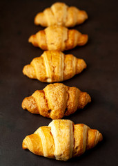 croissants on wooden cutting board, on background  stone, top view