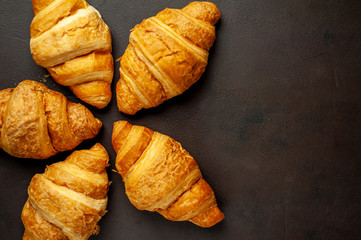 croissants on wooden cutting board, on background  stone, top view