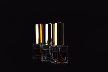 three small bottles of perfume on a dark background