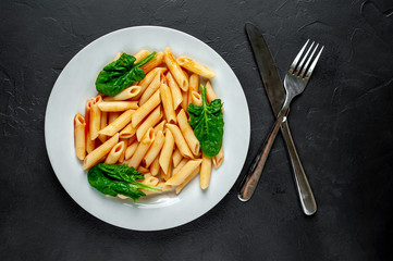 Penne pasta in tomato sauce on concrete background