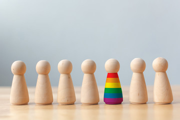 Human rights of LGBT campaign concept. Wooden dolls with rainbow colors are different stand out from crowd