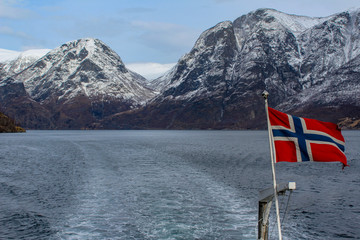 Norwegian flag in the wind during a cruise on the naeroyfjord, Norway