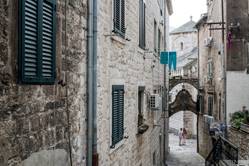 Fototapeta na wymiar Couple framed by the narrow street in the Old Town of Kotor, Montenegro.