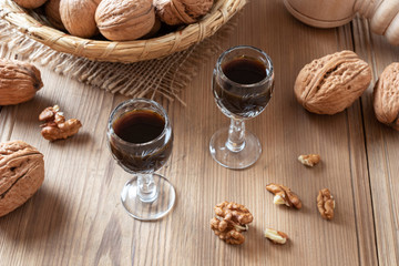 Homemade nut liqueur with walnuts on a table - obrazy, fototapety, plakaty
