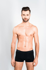 handsome bearded man posing in boxer shorts isolated on grey
