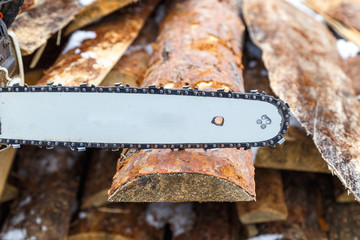 A chainsaw guide bar over the wooden board or  chainsaw in action