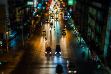 Night traffic in Bangkok. Street in the city center filled with cars passenger buses bikes and taxis. Night city lights up.