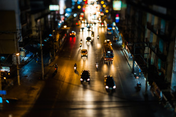 Night traffic in Bangkok. Street in the city center filled with cars passenger buses bikes and taxis. Night city lights up.