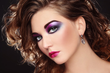 Young beautiful girl with glowing colorful disco make-up and curly hair