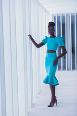 Fototapeta na wymiar Attractive black woman wearing turquoise dress walks the runway