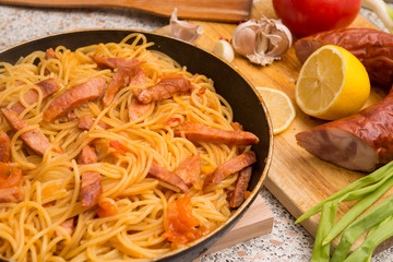 pasta with salami in a pan, lemon, garlic